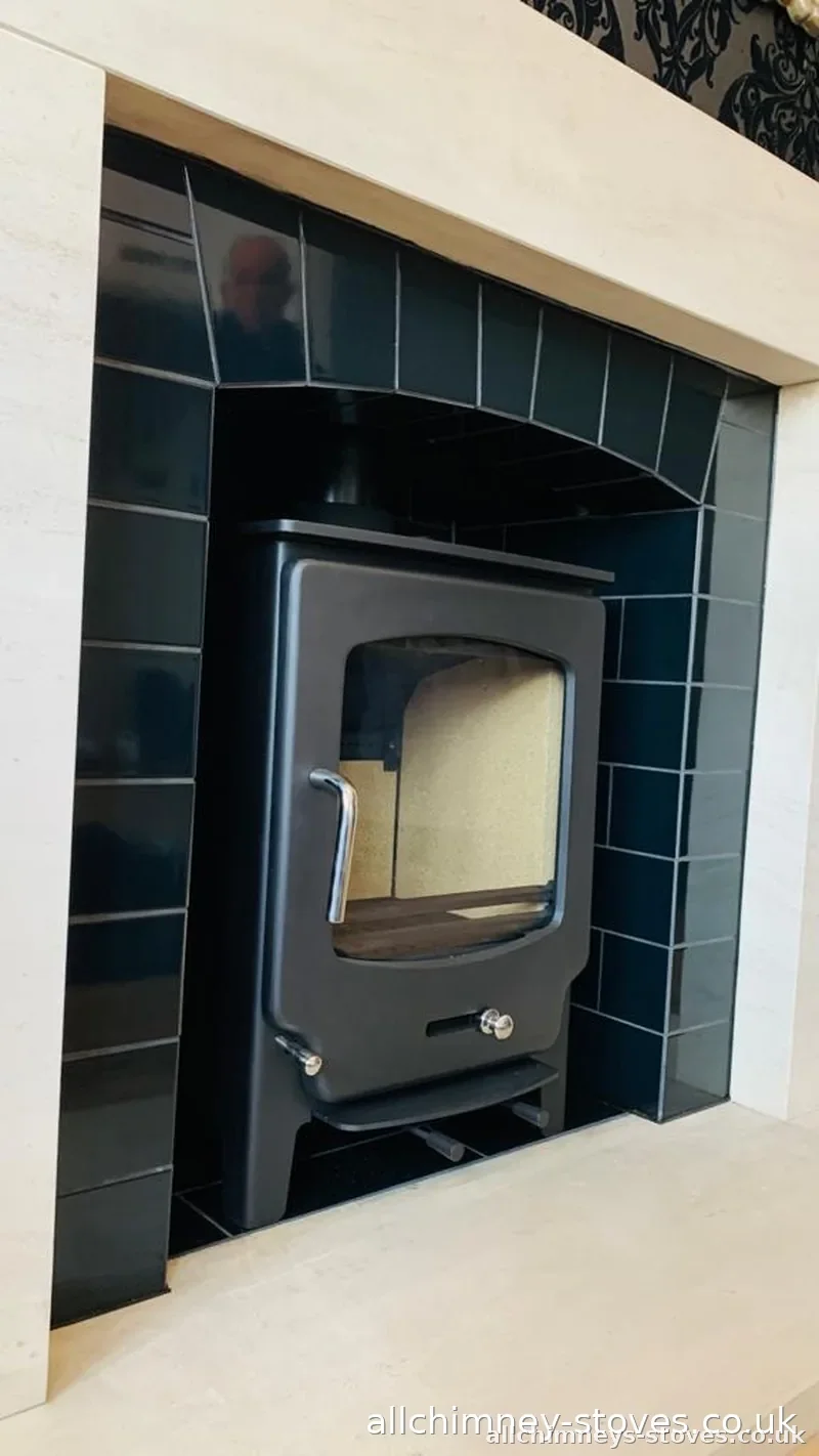 HETAS certified stove fitter — completed install, black tiled arched opening, limestone surround, Allchimney Stoves, Upminster