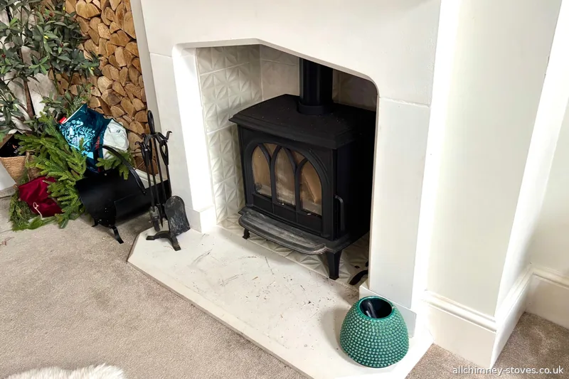 Stovax 5kW wide body wood burning stove, gothic arch door glass, white decorative surround, patterned tiles, Gidea Park Romford