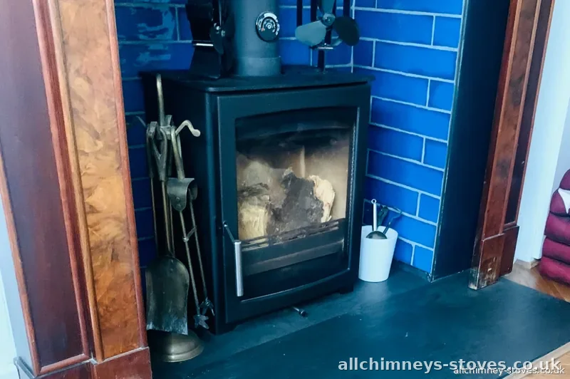 HETAS certified log burner installation — period arched fireplace, burled walnut surround, blue metro tiles, Allchimney Stoves, Rise Park Romford