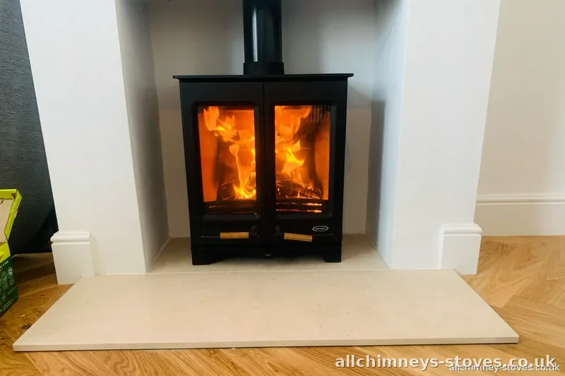HETAS certified wood burning stove installation — completed stove with fire lit on limestone hearth, Allchimney Stoves, Rise Park Romford