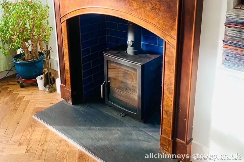 HETAS certified modified stove installation — wood burning stove in period arched surround, blue metro tiles, slate hearth, gas appliance removed, Allchimney Stoves, Hornchurch